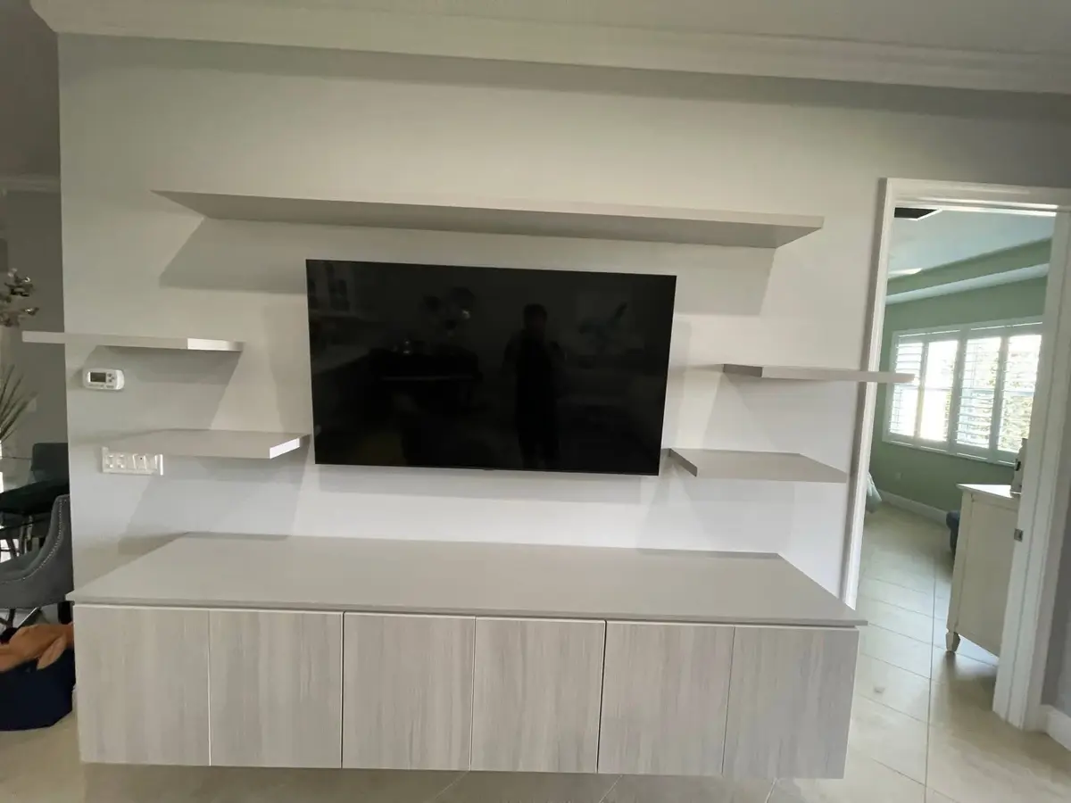 Floating media wall with a mounted television and custom shelving installed by C&C Multiservices in Connecticut